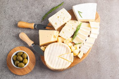 Çeşitli peynirler ve zeytinlerle ahşap tahta. Krem peynir. Camembert peyniri. Parmesan, feta, mavi peynir. İtalyan, Fransız peyniri.
