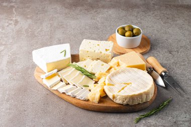 Çeşitli peynirler ve zeytinlerle ahşap tahta. Krem peynir. Camembert peyniri. Parmesan, feta, mavi peynir. İtalyan, Fransız peyniri.