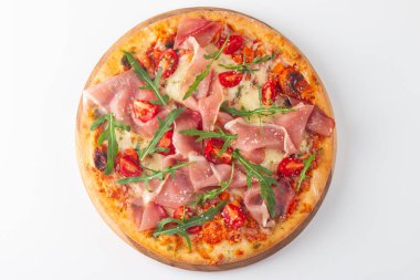 Prosciutto, jambon, roka, domates, pesto, peynir ve parmesanlı pizza. İtalyan mutfağı. 
