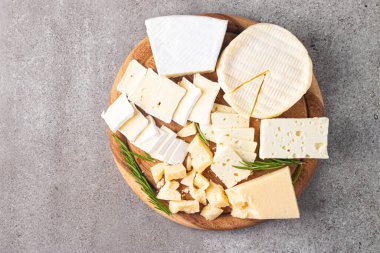 Çeşitli peynirler ve zeytinlerle ahşap tahta. Krem peynir. Camembert peyniri. Parmesan, feta, mavi peynir. İtalyan, Fransız peyniri.