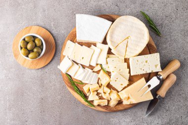 Çeşitli peynirler ve zeytinlerle ahşap tahta. Krem peynir. Camembert peyniri. Parmesan, feta, mavi peynir. İtalyan, Fransız peyniri.
