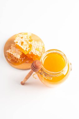 Beyaz arka planda bal damlayan ahşap bir baldan. Sağlıklı organik gıda konsepti. 