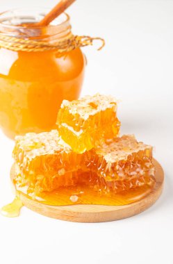 Beyaz arka planda bal damlayan ahşap bir baldan. Sağlıklı organik gıda konsepti. 