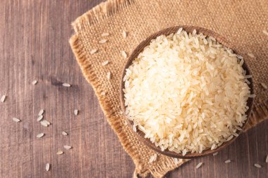 Tahta bir kasede pişmemiş beyaz pirinç. Sağlıklı gevrek kavramı.  