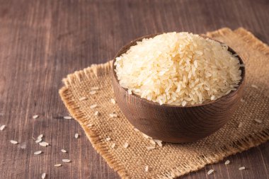 Tahta bir kasede pişmemiş beyaz pirinç. Sağlıklı gevrek kavramı.  