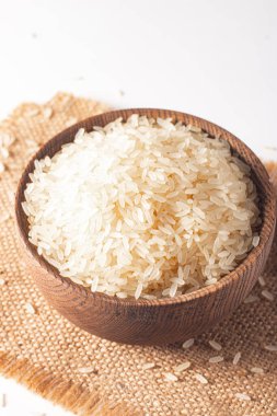 Tahta bir kasede pişmemiş beyaz pirinç. Sağlıklı gevrek kavramı.  