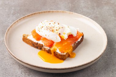 Somon ve peynirli tost üzerine haşlanmış yumurta. Kahvaltı konsepti. Sandviç aç. 