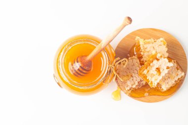 Beyaz arka planda bal damlayan ahşap bir baldan. Sağlıklı organik gıda konsepti. 