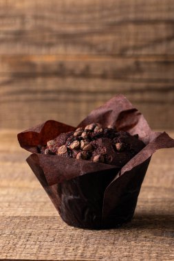 Çikolata kaplı kek, çikolata parçacıkları ve tahta bir masanın üzerine damlalar. 