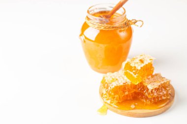 Beyaz arka planda bal damlayan ahşap bir baldan. Sağlıklı organik gıda konsepti. 