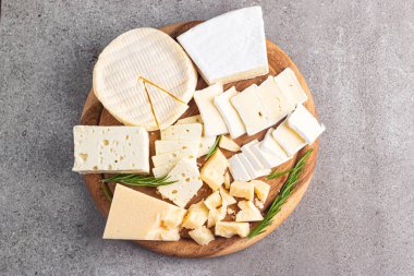 Çeşitli peynirler ve zeytinlerle ahşap tahta. Krem peynir. Camembert peyniri. Parmesan, feta, mavi peynir. İtalyan, Fransız peyniri.