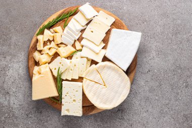 Çeşitli peynirler ve zeytinlerle ahşap tahta. Krem peynir. Camembert peyniri. Parmesan, feta, mavi peynir. İtalyan, Fransız peyniri.