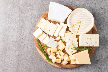 Çeşitli peynirler ve zeytinlerle ahşap tahta. Krem peynir. Camembert peyniri. Parmesan, feta, mavi peynir. İtalyan, Fransız peyniri.