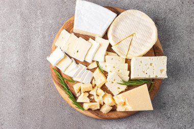 Çeşitli peynirler ve zeytinlerle ahşap tahta. Krem peynir. Camembert peyniri. Parmesan, feta, mavi peynir. İtalyan, Fransız peyniri.