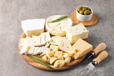Çeşitli peynirler ve zeytinlerle ahşap tahta. Krem peynir. Camembert peyniri. Parmesan, feta, mavi peynir. İtalyan, Fransız peyniri.