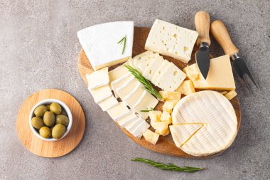 Çeşitli peynirler ve zeytinlerle ahşap tahta. Krem peynir. Camembert peyniri. Parmesan, feta, mavi peynir. İtalyan, Fransız peyniri.