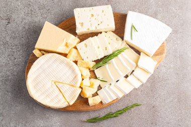 Çeşitli peynirler ve zeytinlerle ahşap tahta. Krem peynir. Camembert peyniri. Parmesan, feta, mavi peynir. İtalyan, Fransız peyniri.