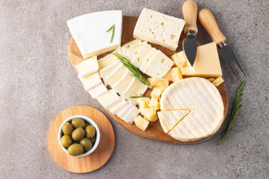 Çeşitli peynirler ve zeytinlerle ahşap tahta. Krem peynir. Camembert peyniri. Parmesan, feta, mavi peynir. İtalyan, Fransız peyniri.