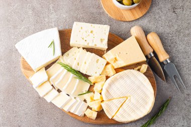 Çeşitli peynirler ve zeytinlerle ahşap tahta. Krem peynir. Camembert peyniri. Parmesan, feta, mavi peynir. İtalyan, Fransız peyniri.