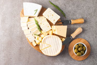 Çeşitli peynirler ve zeytinlerle ahşap tahta. Krem peynir. Camembert peyniri. Parmesan, feta, mavi peynir. İtalyan, Fransız peyniri.