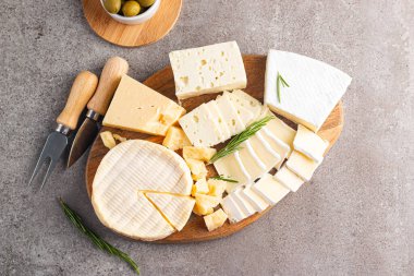 Çeşitli peynirler ve zeytinlerle ahşap tahta. Krem peynir. Camembert peyniri. Parmesan, feta, mavi peynir. İtalyan, Fransız peyniri.