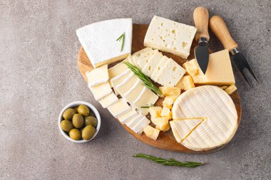 Çeşitli peynirler ve zeytinlerle ahşap tahta. Krem peynir. Camembert peyniri. Parmesan, feta, mavi peynir. İtalyan, Fransız peyniri.