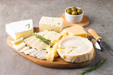 Çeşitli peynirler ve zeytinlerle ahşap tahta. Krem peynir. Camembert peyniri. Parmesan, feta, mavi peynir. İtalyan, Fransız peyniri.