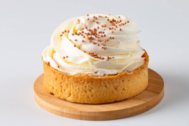 Krem şantili limonlu turtalar, beyaz arka planda çikolata parçaları.