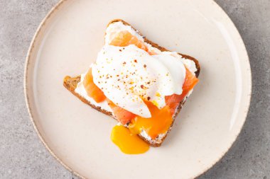 Somon ve peynirli tost üzerine haşlanmış yumurta. Kahvaltı konsepti. Sandviç aç. 