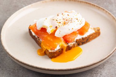 Somon ve peynirli tost üzerine haşlanmış yumurta. Kahvaltı konsepti. Sandviç aç. 
