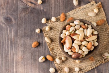 Ahşap arka planda sağlıklı fındık karışımı. Badem, fındık, fındık, fıstık, fıstık, fıstık, Brezilya fıstığı.