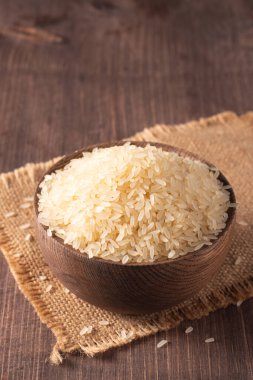 Tahta bir kasede pişmemiş beyaz pirinç. Sağlıklı gevrek kavramı.  