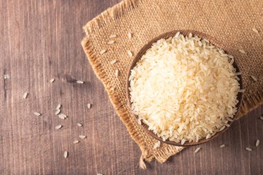 Tahta bir kasede pişmemiş beyaz pirinç. Sağlıklı gevrek kavramı.  