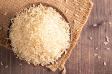 Tahta bir kasede pişmemiş beyaz pirinç. Sağlıklı gevrek kavramı.  