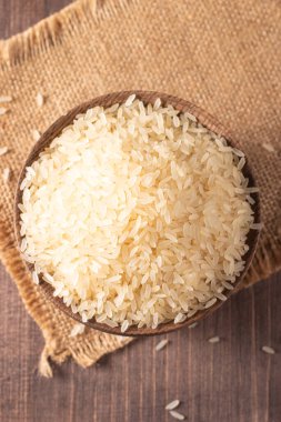 Tahta bir kasede pişmemiş beyaz pirinç. Sağlıklı gevrek kavramı.  