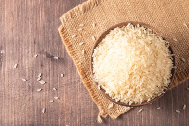 Tahta bir kasede pişmemiş beyaz pirinç. Sağlıklı gevrek kavramı.  