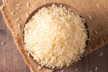 Tahta bir kasede pişmemiş beyaz pirinç. Sağlıklı gevrek kavramı.  