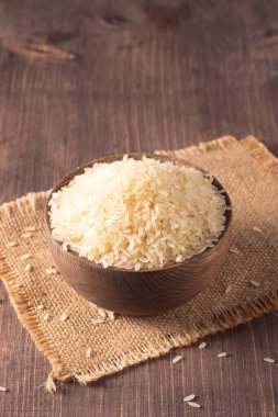 Tahta bir kasede pişmemiş beyaz pirinç. Sağlıklı gevrek kavramı.  
