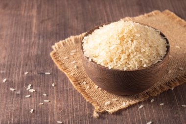 Tahta bir kasede pişmemiş beyaz pirinç. Sağlıklı gevrek kavramı.  