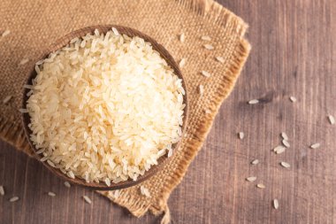 Tahta bir kasede pişmemiş beyaz pirinç. Sağlıklı gevrek kavramı.  