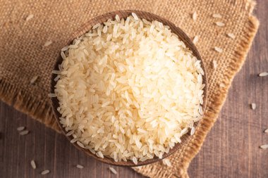 Tahta bir kasede pişmemiş beyaz pirinç. Sağlıklı gevrek kavramı.  