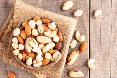 Ahşap arka planda sağlıklı fındık karışımı. Badem, fındık, fındık, fıstık, fıstık, fıstık, Brezilya fıstığı.