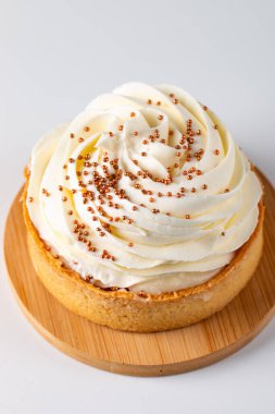 Krem şantili limonlu turtalar, beyaz arka planda çikolata parçaları.