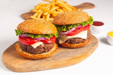 Sığır eti, soğan, domates, marul, peynir ve baharattan yapılmış hamburger. Taze burger yakın plan. Çizburger..