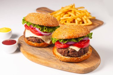 Sığır eti, soğan, domates, marul, peynir ve baharattan yapılmış hamburger. Taze burger yakın plan. Çizburger..