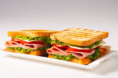 Jambonlu sandviç, peynirli, domatesli ve marullu.