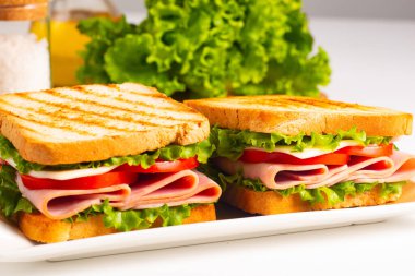 Jambonlu sandviç, peynirli, domatesli ve marullu.