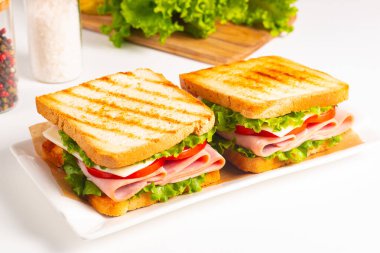 Jambonlu sandviç, peynirli, domatesli ve marullu.