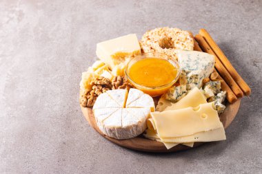 Çeşitli peynirler ve zeytinlerle ahşap tahta. Krem peynir. Camembert peyniri. Parmesan, feta, mavi peynir. İtalyan, Fransız peyniri