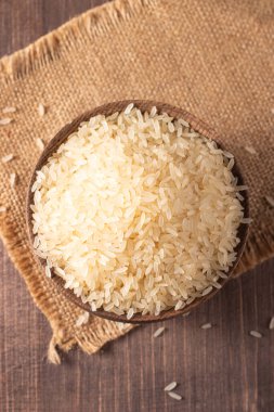 Tahta bir kasede pişmemiş beyaz pirinç. Sağlıklı gevrek kavramı